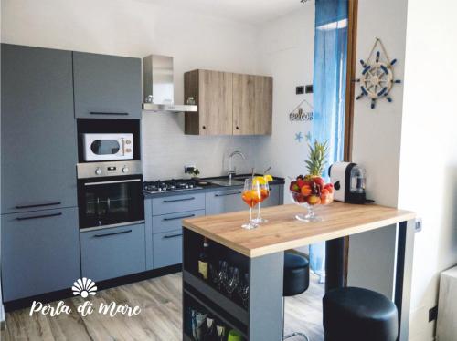 a kitchen with blue cabinets and a counter with drinks on it at Appartamento Perla di Mare in Piombino