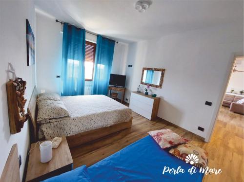 a bedroom with two beds and a table and a mirror at Appartamento Perla di Mare in Piombino
