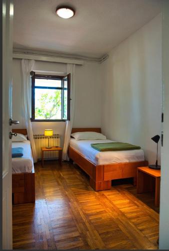 a bedroom with two beds and a window at Apartments Kokić in Zavala