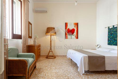 a bedroom with a bed and a chair at Il rifugio dei Narratori in Marina di Mancaversa