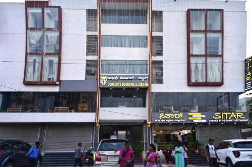 Leute, die vor einem hohen Gebäude laufen in der Unterkunft KK Comforts Boarding and Lodging in Bangalore