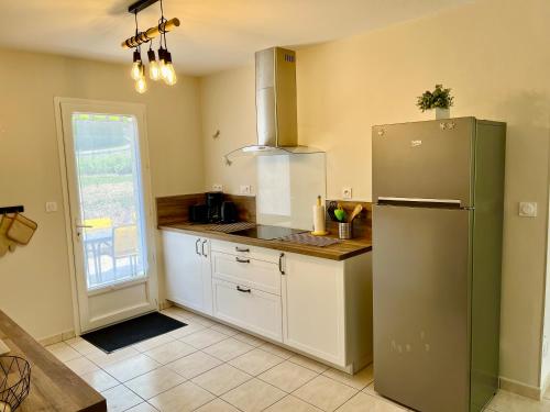 Il comprend une cuisine équipée d'un réfrigérateur en acier inoxydable et une fenêtre. dans l'établissement Gîte Basilic, à Saint-Aignan