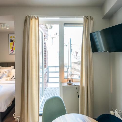 a hotel room with a bed and a balcony at Japie rooms - in the heart of Antwerp in Antwerp