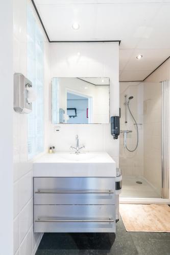 a white bathroom with a sink and a mirror at Japie rooms - in the heart of Antwerp in Antwerp