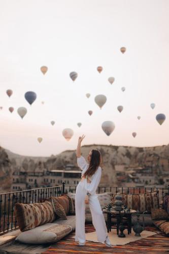 a woman standing on a roof with hearts at Zara Cave Hotel in Goreme