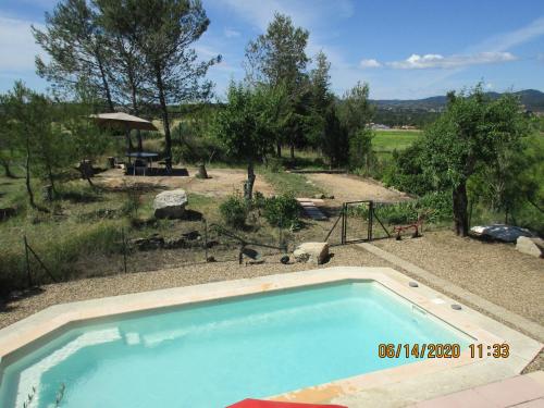- une piscine dans une cour avec une aire de jeux dans l'établissement Le Mas du Sourdet, à Saint-Victor-de-Malcap