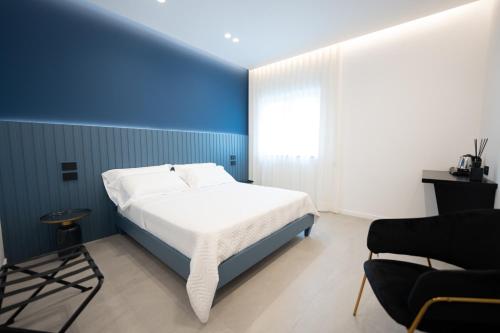 um quarto azul e branco com uma cama e uma cadeira em BMC Home em Boscotrecase