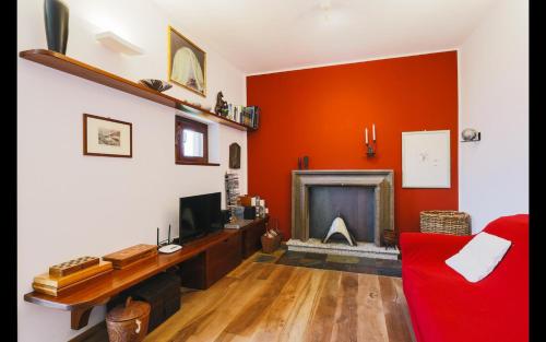 a living room with orange walls and a fireplace at Harry's Villa Lenno - Lake Como in Lenno