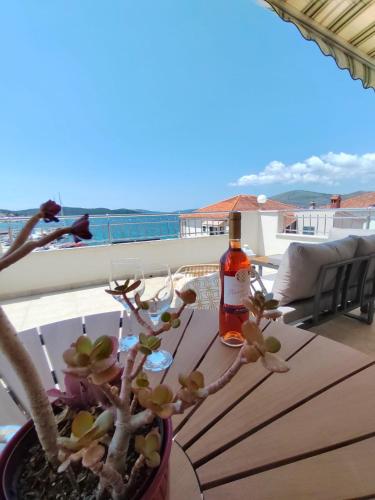 a bottle of wine and a plant on a table at Apartment Čiovo Radić in Trogir