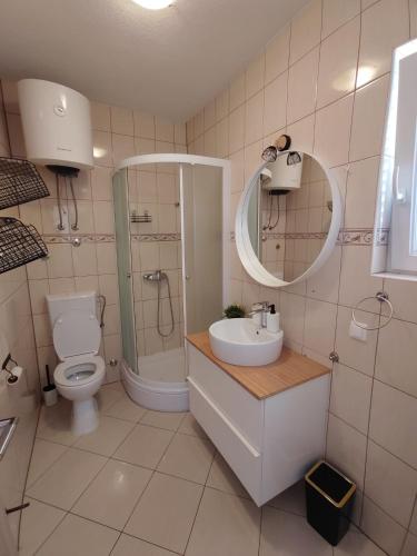 a bathroom with a toilet and a sink and a mirror at Apartment Čiovo Radić in Trogir