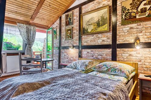sypialnia z łóżkiem i ceglaną ścianą w obiekcie Głęboki Jar w Świeradowie Zdroju