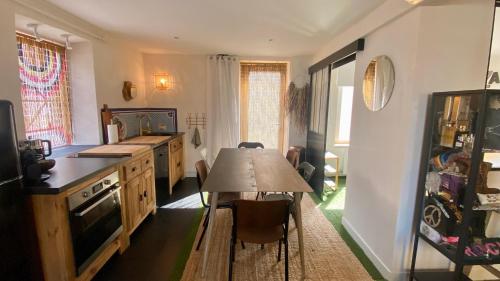 a kitchen with a table and a dining room at La MaisonneTTe d'ElodibiZa ! in Moret-sur-Loing