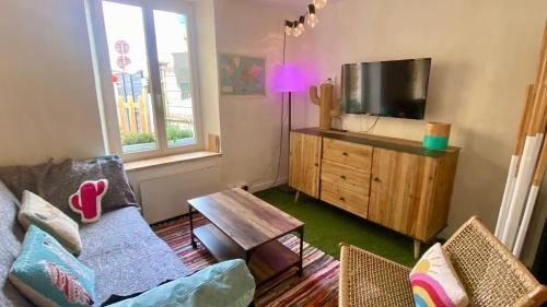 a living room with a couch and a tv at La MaisonneTTe d'ElodibiZa ! in Moret-sur-Loing