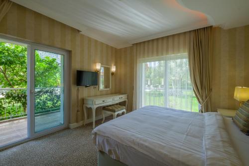 a bedroom with a bed and a window and a desk at Grand Gocek Hotel in Göcek
