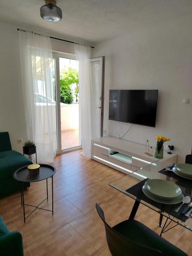 a living room with a flat screen tv on a wall at Apartment Čiovo Radić in Trogir