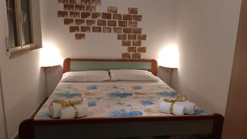 a bedroom with a bed with two bags on it at TONNARA HOUSE AND HOLIDAY in Avola