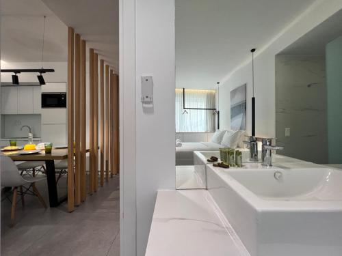 a white bathroom with a sink and a living room at The Dazzling Glimpse Acropolis Suites in Athens