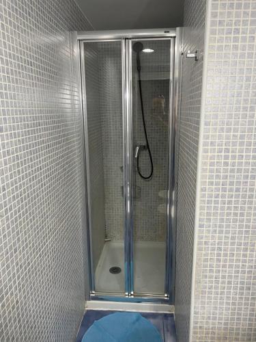 y baño con ducha y puerta de cristal. en Apartamento Asuncion, en Benidorm