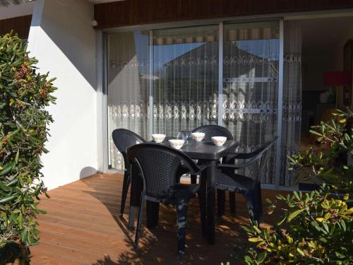 une table noire et des chaises sur un balcon dans l'établissement Appartement T2 tout équipé, 4 couchages, proche plage et centre - Parking privé, Le Grau-du-Roi - FR-1-250-102, au Grau-du-Roi