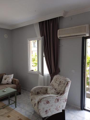 uma sala de estar com uma cadeira e uma janela em Beldibi apartment / house / hotel em Antalya