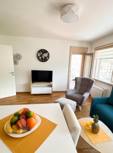 a living room with a plate of fruit on a table at Four Views Apartments in Budva