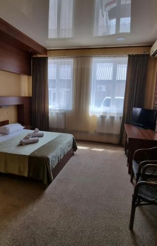a bedroom with a bed and a desk and a window at Hotel Salem in Aktau