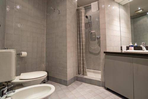 uma casa de banho com um WC, um chuveiro e um lavatório. em Flower apartment - Royal Welcome em Verona
