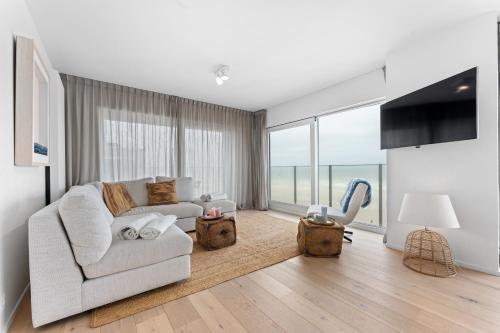a living room with a couch and a large window at Seaflow-Holiday appartment with frontal sea view in Oostduinkerke