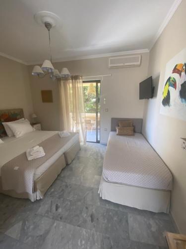 a bedroom with two beds and a large window at Aelia Houses in Agia Marina Aegina