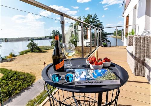 stół z butelką wina i miską owoców w obiekcie Perfect View - najlepszy widok w Iławie plus garaż podziemny, winda, Netflix w Iławie