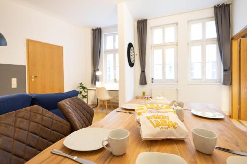 a dining room table with a happy birthday pillow on it at Ko-Living Space an der Oper - Street Art Design Apartments in Halle an der Saale