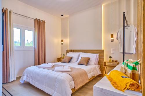 a bedroom with a large bed and a window at Limosa Beach House Corfu in Agios Georgios Pagon