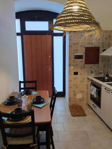a kitchen with a table with chairs and a chandelier at CASA JO in Bari