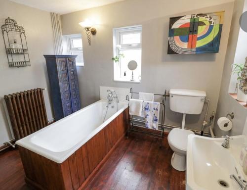 La salle de bains est pourvue d'une baignoire, de toilettes et d'un lavabo. dans l'établissement Lovely Comfortable 3 Bed Home, Worcester, à Worcester