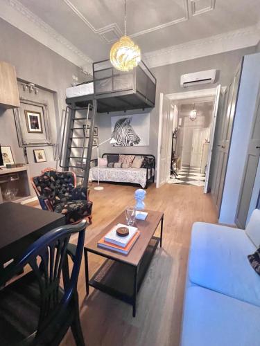 ein Wohnzimmer mit einem Sofa, einem Tisch und einem Etagenbett in der Unterkunft CENTRAL DAINTY in Zagreb