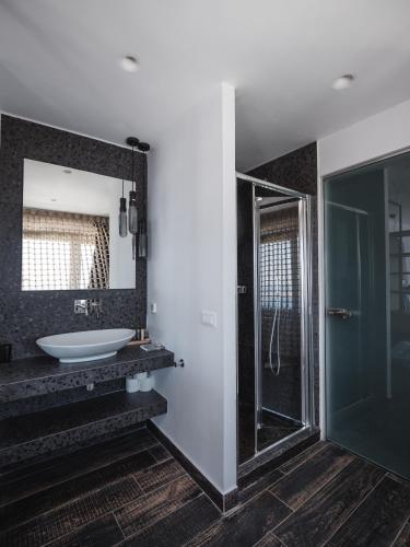 a bathroom with a sink and a mirror at Galaxy Suites & Villas in Imerovigli