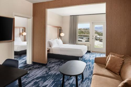 a hotel room with two beds and a couch at Fairfield Inn & Suites by Marriott West Kelowna in West Kelowna