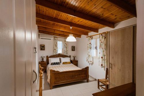 a bedroom with a bed and a wooden ceiling at Minas Farm Cottage in Gouves