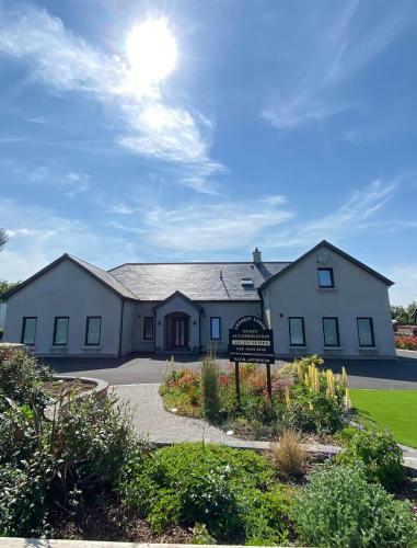 een wit huis met een bord ervoor bij Ardbrin Lodge in Dunadry