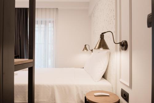 una camera d'albergo con un letto con una lampada e una finestra di Persona Hotel Galata a Istanbul