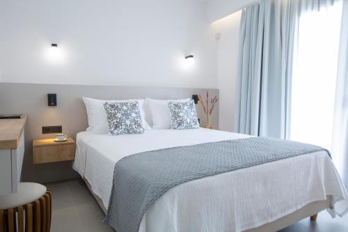 a bedroom with a white bed and a window at Achillion Suites in Lefkada Town