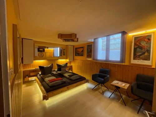 a bedroom with a bed and two chairs and a window at Direkt am Main in Karlstadt