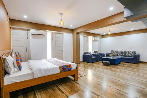 FabHotel Skylight Inn Near Medanta Hospital في جورجاون: غرفة نوم مع سرير وغرفة معيشة