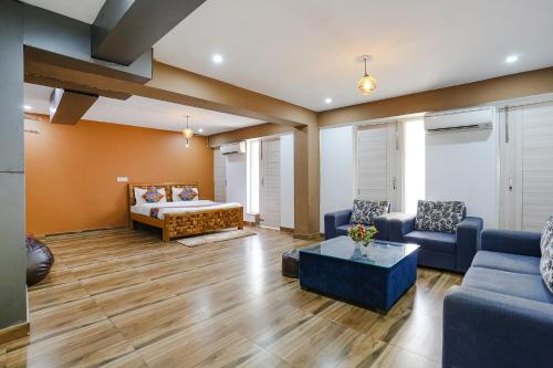 a living room with a couch and a bed at FabHotel Skylight Inn Near Medanta Hospital in Gurgaon