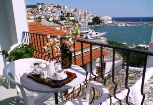 a table on a balcony with a view of a harbor at Regina Hotel in Skopelos Town