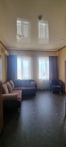 a living room with couches and windows at Hotel Salem in Aktau
