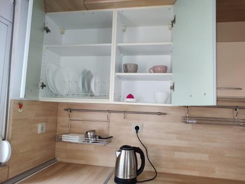 a kitchen with white cabinets and a tea kettle at Eva Rooms in Preveza