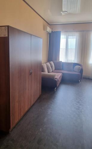 a living room with a couch and a wooden cabinet at Hotel Salem in Aktau