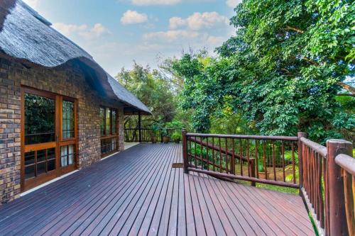 a large wooden deck with a building and trees at Kruger Park Lodge Unit No. 254 in Hazyview