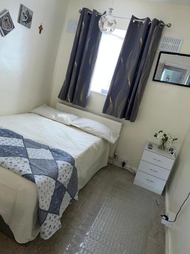 a small bedroom with a bed and a window at Single room with Smart Tv in Luton